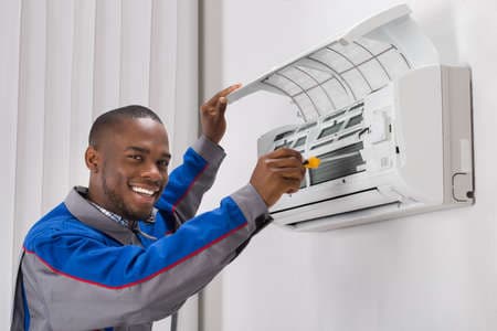 Technicien NOVACLIM entretenant un climatiseur split mural
